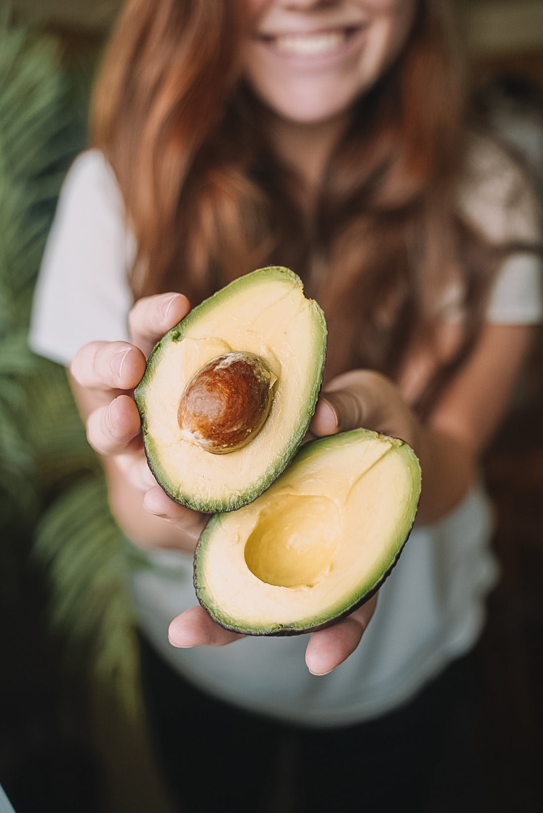 A woman hold out avocado 