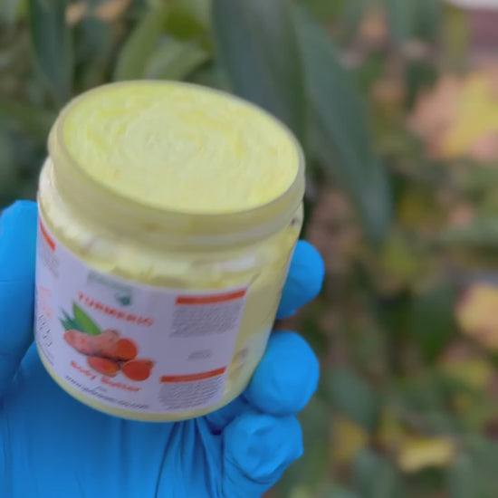 Holding turmeric body butter out in nature 